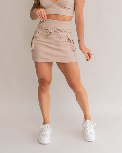 Short saia cargo areia feminino frente bolsos laterais cordão amarração tênis branco