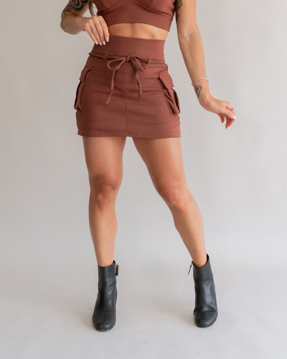 Short saia cargo marrom feminino frente bolsos laterais cordão amarração bota preta