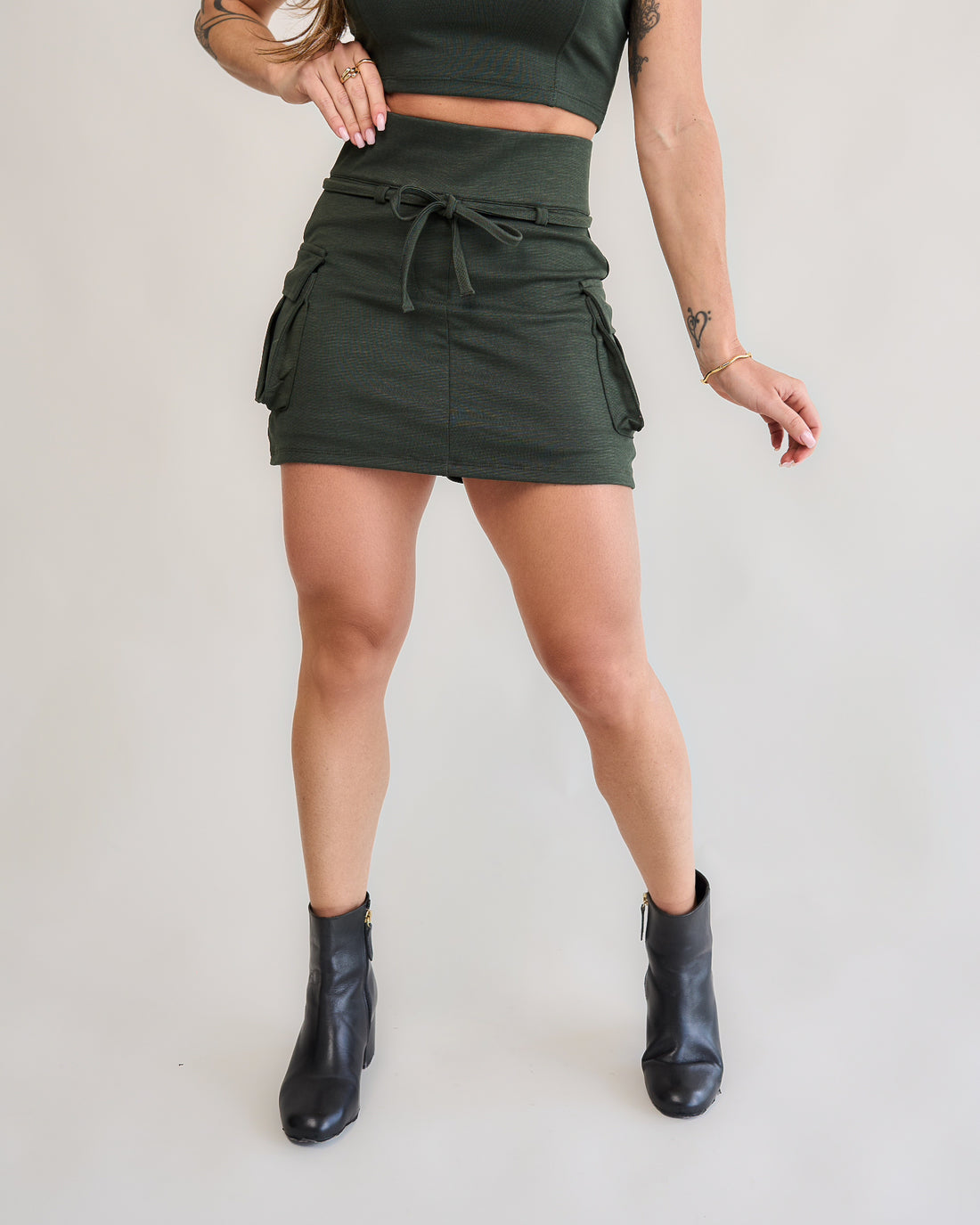 Short saia cargo verde militar feminino frente bolsos laterais cordão amarração bota preta