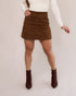 Short saia suede caramelo feminino frente com blusa manga longa off white e bota caramelo